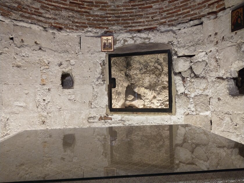 The window into a cracked stone believed to be a remnant of Cavalry, the hill on which Jesus was crucified.